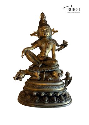 a bronze statue of a woman sitting on top of a snake