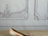 pair of women ' s shoes sitting on a wooden floor in front of a wall