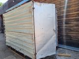 a white refrigerator sitting on a pallet outside of a building