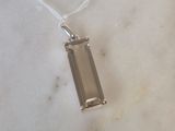 pendentif en argent massif orné d'un quartz fumé posé sur un fond en marbre blanc