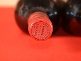 two bottles of wine sitting on a red table