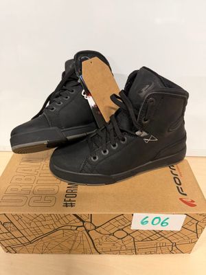 une paire de chaussures noires posée sur une boîte en carton