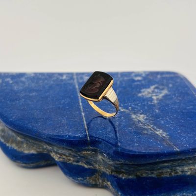an image of a ring with a black stone on top of a blue stone