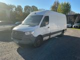 La camionnette blanche est garée sur le parking, à côté de quelques voitures.