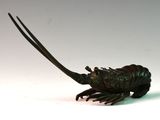 statue d'un homard posée sur une surface blanche, avec un fond blanc