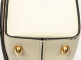 a close up of a white purse with gold studded handles