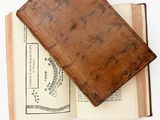 an old book on top of an old book on a table