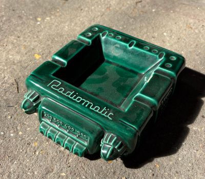 un cendrier vert posé par terre