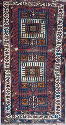un tapis très ancien aux couleurs et motifs variés