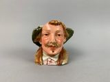 une figurine représentant un homme moustachu et coiffé d'un chapeau