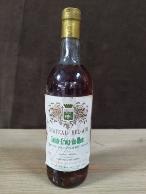 une vieille bouteille de vin posée sur une table en bois