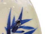 a close up of a blue and white plate with leaves on it