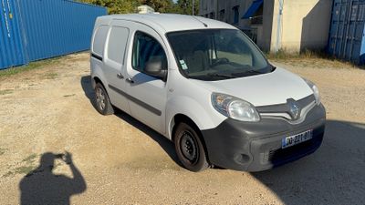 a white van parked in a parking lot with a man taking a picture