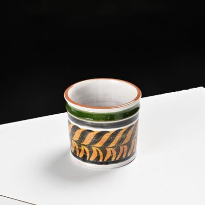 a small cup sitting on top of a white table
