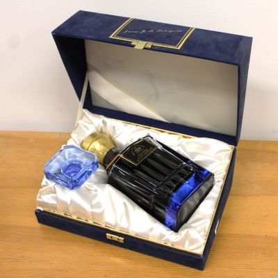 a bottle of perfume in a blue box on a table