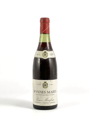 une vieille bouteille de vin posée sur une surface blanche