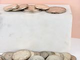 a white marble block with a bunch of coins on it