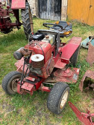 un tracteur rouge assis dans l'herbe