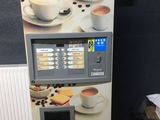 un distributeur automatique de café sur lequel est posée une tasse de café
