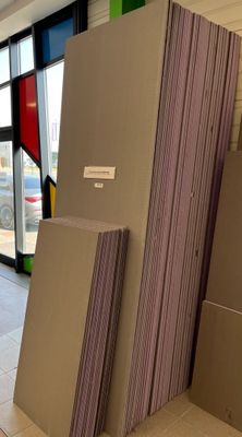 Plusieurs morceaux de carton sont empilés les uns sur les autres devant une grande fenêtre