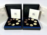 two boxes with four different coins in them on a white surface