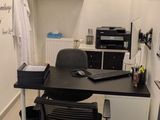 un bureau avec une chaise et un ordinateur portable posé dessus, dans une pièce