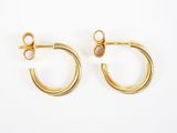 une paire de boucles d'oreilles en or sur fond blanc