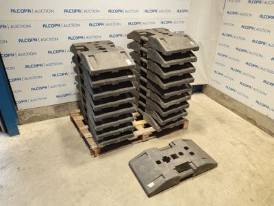 Plusieurs morceaux de plastique sont empilés sur une palette devant un mur