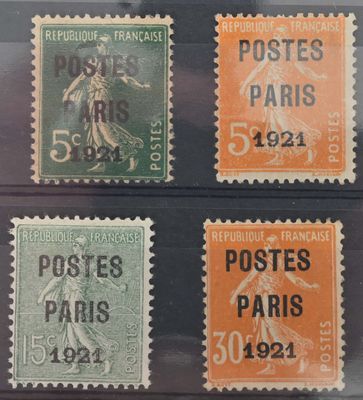 quatre timbres différents, de couleurs et de tailles variées, présentés dans un présentoir