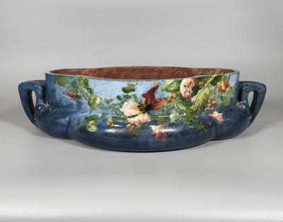 un gros plan d'un bol bleu orné de fleurs