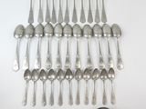 a lot of silver spoons and spoons on the table