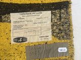 a close up of a piece of woven fabric with a tag on it