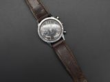 a close up of a watch on a black surface