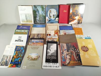Plusieurs livres sont empilés sur une table devant un fond blanc.