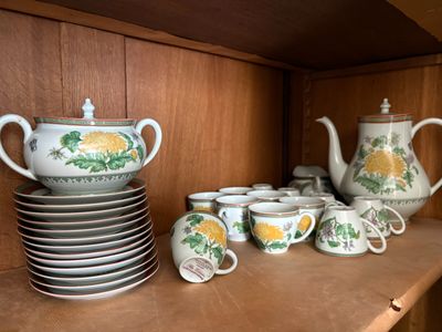 de nombreuses tasses et soucoupes sur l'étagère de la cuisine
