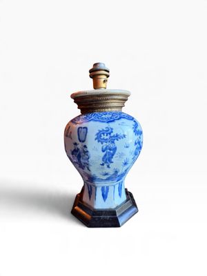un vase bleu et blanc muni d'un couvercle, posé sur un socle