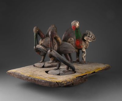 une photo d'une sculpture représentant un groupe d'oiseaux perchés sur un morceau de bois