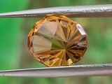 un gros plan d'un diamant jaune tenu par une paire de pinces
