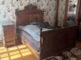 a bedroom with a bed, dresser, mirror, and other items on the floor