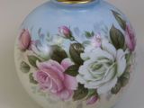 un vase bleu orné de fleurs roses et blanches