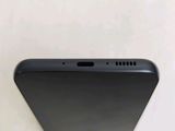 the back of a black cell phone sitting on top of a table