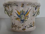 a white vase with a blue and yellow design on it