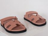 a pair of pink sandals with black soles on a white surface