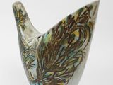 a ceramic bird that is sitting on a white surface