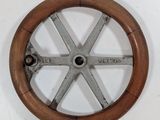 a wooden steering wheel with a metal spoke on it