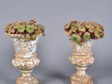 pair of vases with flowers in them on a gray surface