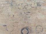 a piece of wood that has been scratched and has a hole in it