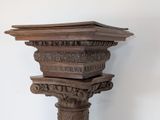 a tall wooden column with carvings on top of it