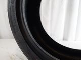 tire on a white surface with a white curtain in the background