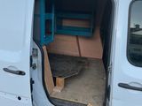 une camionnette blanche dont la porte est ouverte, garée sur le bord de la route
